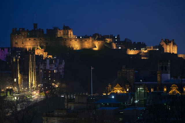 Edinburgh Castle is illuminated yellow during the National Day of Reflection