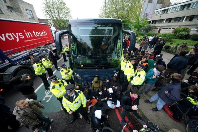 Police try and stop protesters forming a blockade around a coach 