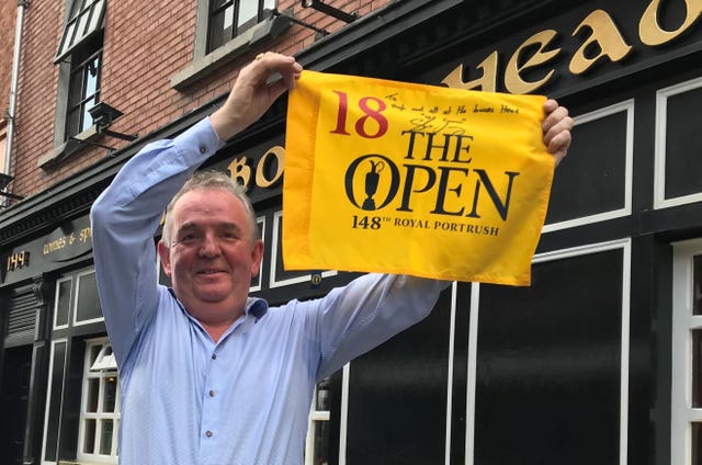 Owner of Boar’s Head Hugh Hourican with the flag from the 18th hole of The Open after Shane Lowry arrived with friends and supporters to celebrate