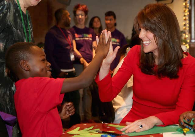 The Duchess of Cambridge is given a high-five as she attends the Anna Freud Centre Family School Christmas party in north London. Chris Jackson/PA Wire