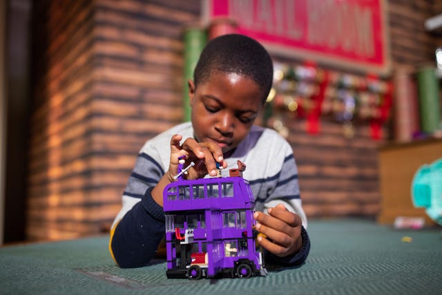 Peter Olunloyo, eight, plays with a Harry Potter Knight bus toy by Lego
