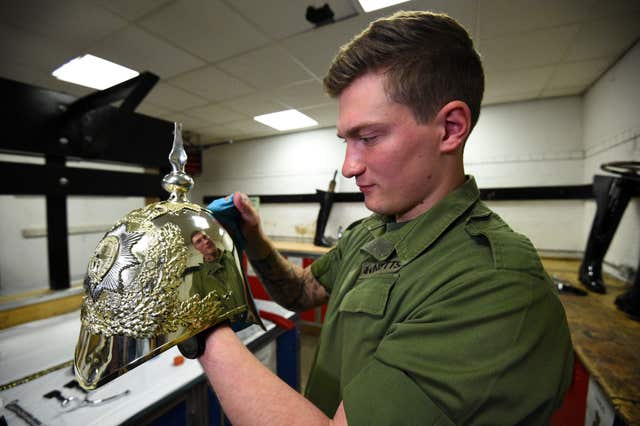 Polishing a helmet in preparation for the royal wedding at Windsor Castle (Kirsty O’Connor/PA)