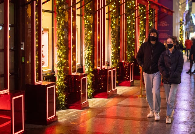 Shoppers pass Christmas light displays on New Bond Street in central London