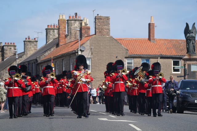 Members wearing their full ceremonial dress of scarlet tunics and bearskin caps, parade through Berwick-upon-Tweed