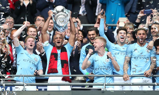 Vincent Kompany, centre, lifts the FA Cup