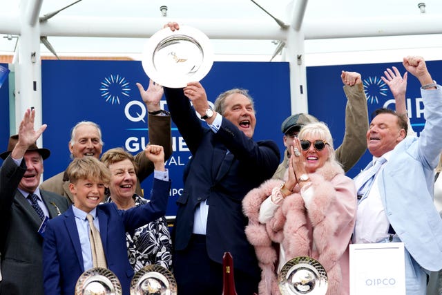 Harry Herbert celebrates with the trophy after Cachet's Guineas success