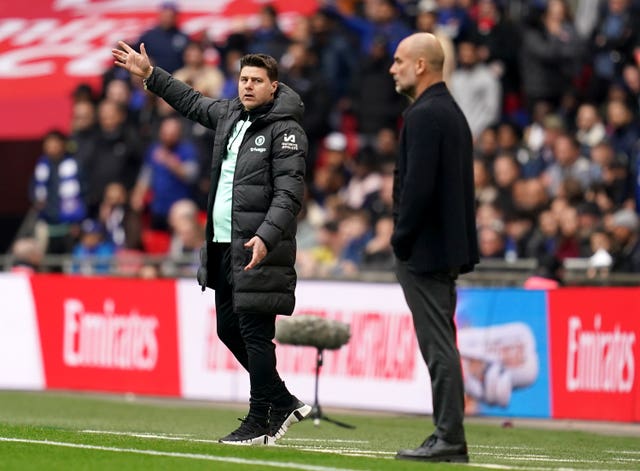 Mauricio Pochettino stands on the touchline next to Pep Guardiola