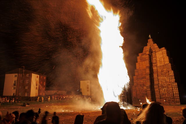 Members of the public watch one of the two Loyalist Corcrain Redmanville (LCR) bonfires in Portadown