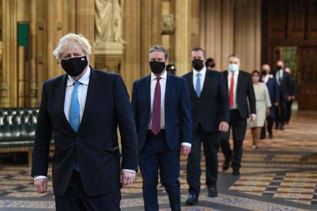 Prime Minister Boris Johnson (left) and Labour leader Sir Keir Starmer (2nd left) walk through the Central Lobby