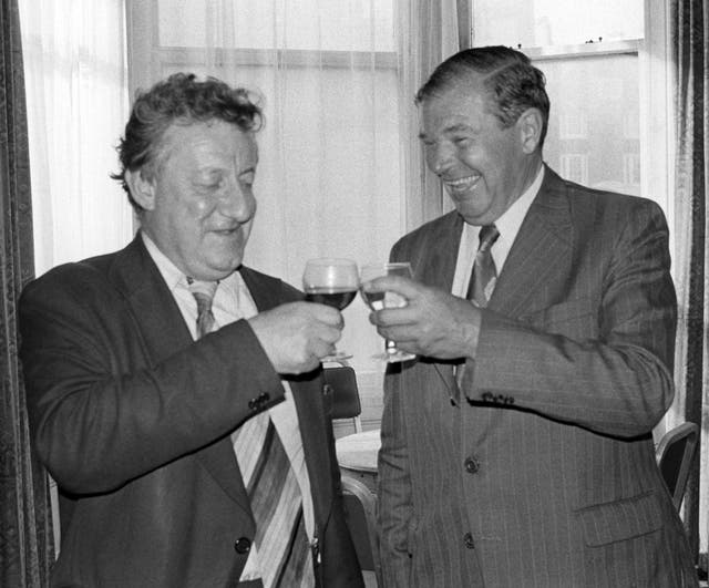 Moncrieff and PA's then-Parliamentary Editor Cyril Arthur toast one another in 1978 (PA)