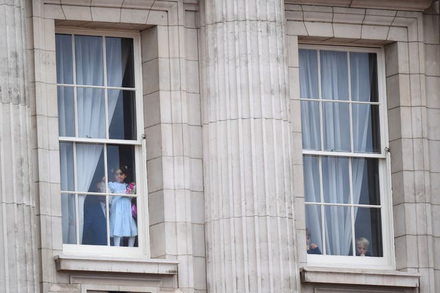 Children look out from from Buckingham Palace 