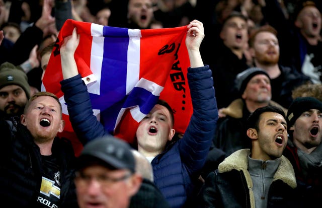 Manchester United fans hold up a Norwegian flag