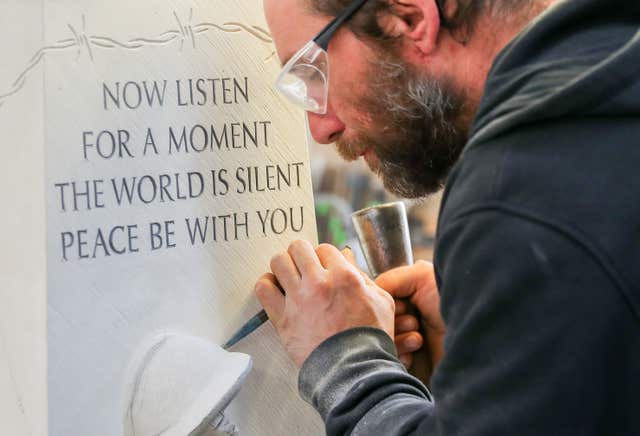 Stone masons from Salisbury cathedral work on a war memorial in their workshop which was designed by prisoners from Erlestoke prison (Andrew Matthews/PA)