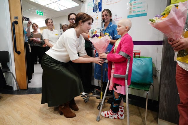 Cancer patient Lola Belle Tucker presents Eugenie with flowers