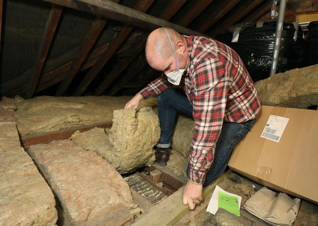 Richard Burr installing loft insulation (Philip Toscano/PA)