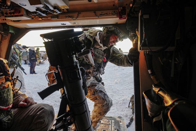 Estonian soldiers lift an anti-tank weapon into a tank on the Tapa range