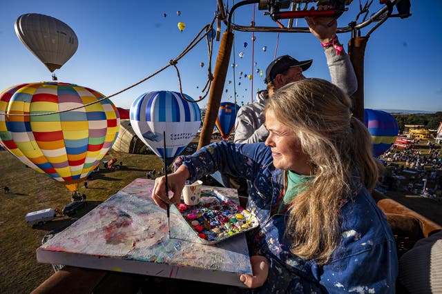 Artist Emily Powell painting in a hot air balloon basket