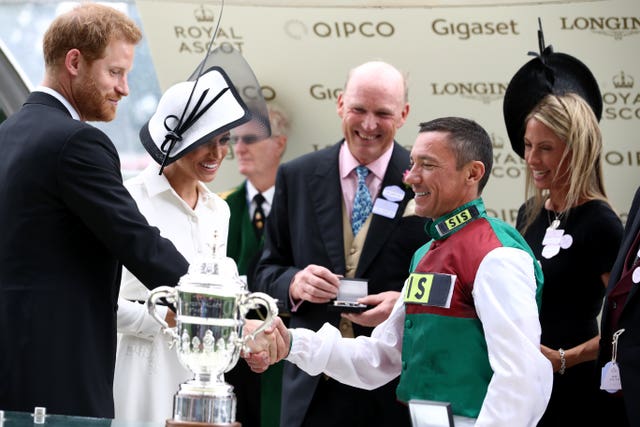 Jockey Frankie Dettori is presented with the trophy by the Duke and Duchess of Sussex