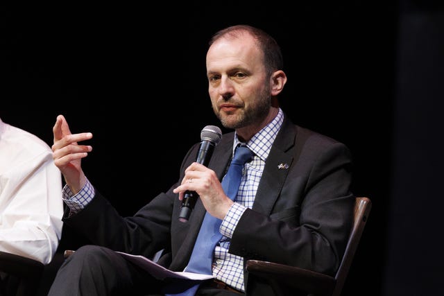 Stephen Gethins seated and speaking into a microphone he is holding