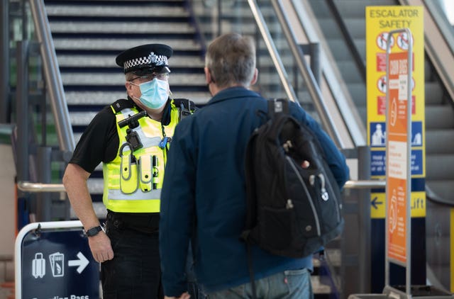 An officer from Avon and Somerset Police chats with a passenger at Bristol Airport