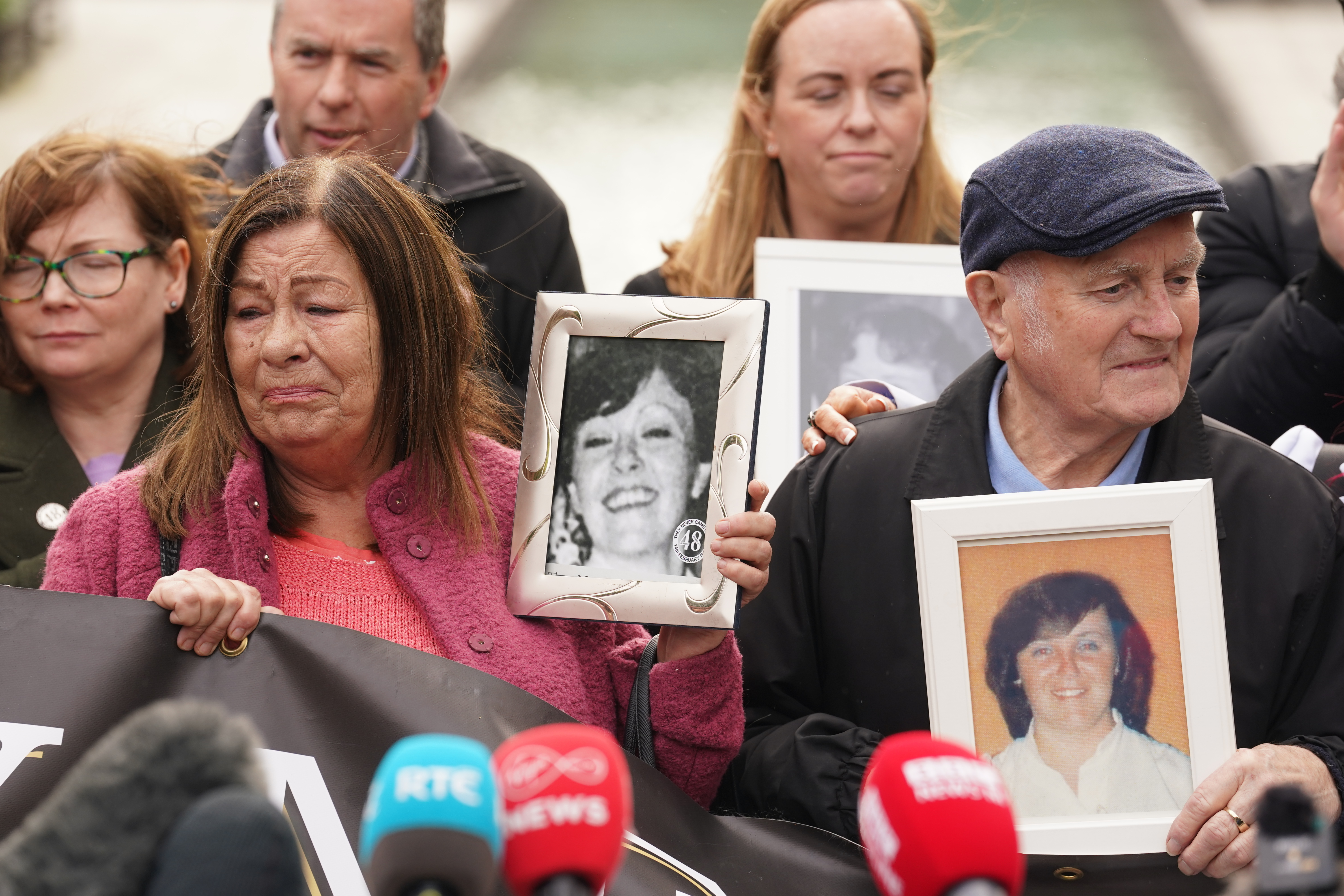 Survivors, family and ers hold pictures of those they lost