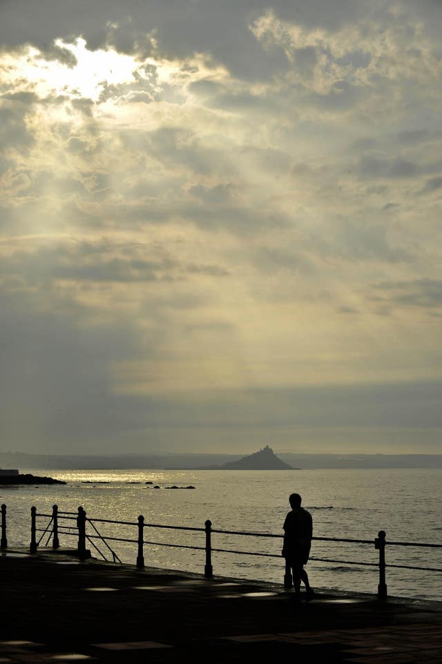 Early morning sunlight breaks through heavy clouds over Penzance