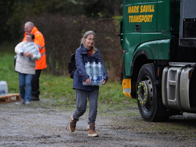 A woman carries bottled water