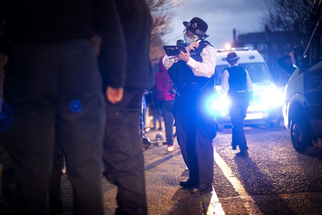 A police officer searches a suspect