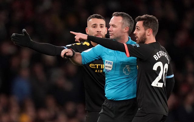 Manchester City's Nicolas Otamendi (left) and Bernardo Silva (right) speak with referee Paul Tierney during their victory over Arsenal