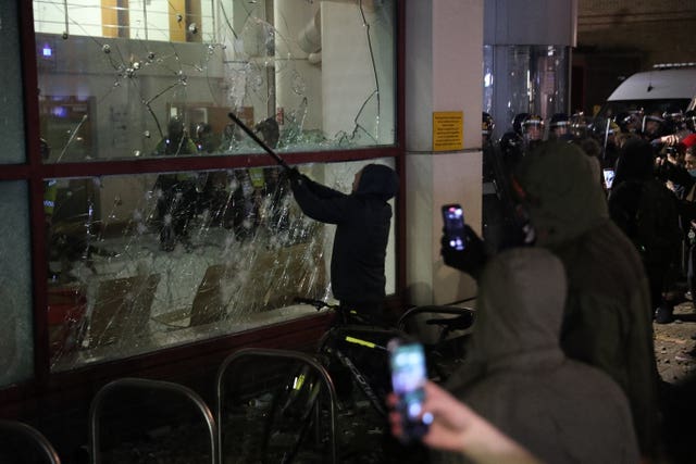 A protester smashing a window at Bridewell Police Station