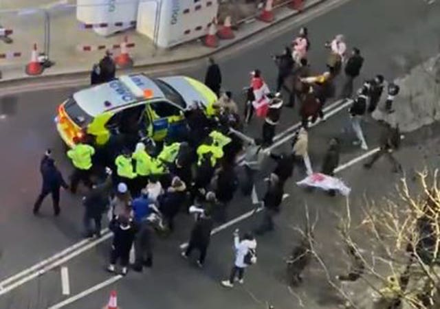 Keir Starmer being put into a police car to get away from protestors