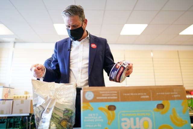 Labour leader Sir Keir Starmer packs a box during a visit to a food bank