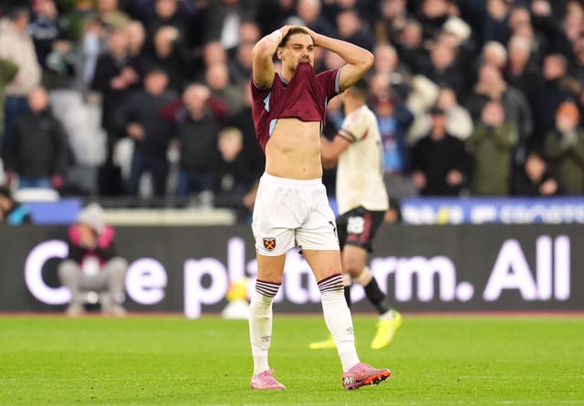 West Ham midfielder Lucas Paqueta puts his hands on his head and with his shirt in his mouth