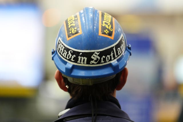 A workman in hardhat reading 'Made in Scotland'