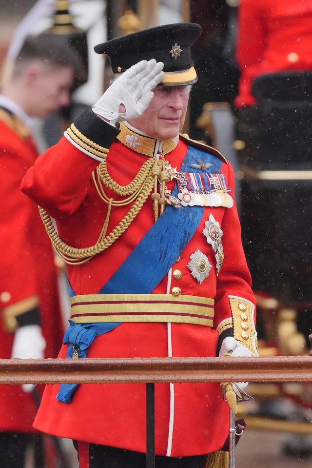 King Charles III salutes outside Buckingham Palace after the Trooping the Colour ceremony