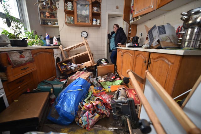 Rachel Cox inspects the damage to her home in Oxford street, Nantgarw, following Storm Dennis (Ben Birchall/PA).