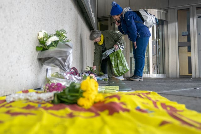 A Scottish lion flag and flowers left outside the Scottish Parliament in Edinburgh