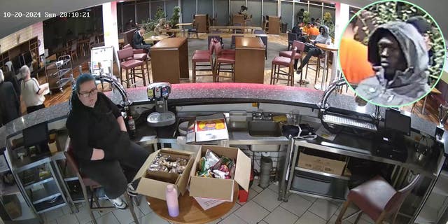 Deng Chol Majek seated in a hotel reception, starting at receptionist Rhiannon Whyte