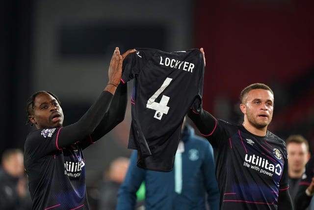 Luton's Pelly Ruddock Mpanzu and Carlton Morris celebrate at the final whistle with a Tom Lockyer shirt 