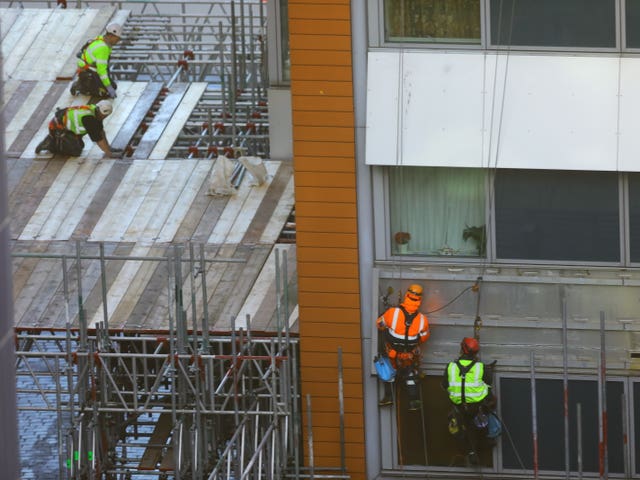 Workmen remove the cladding from the facade of a block of flats in Paddington, north London.