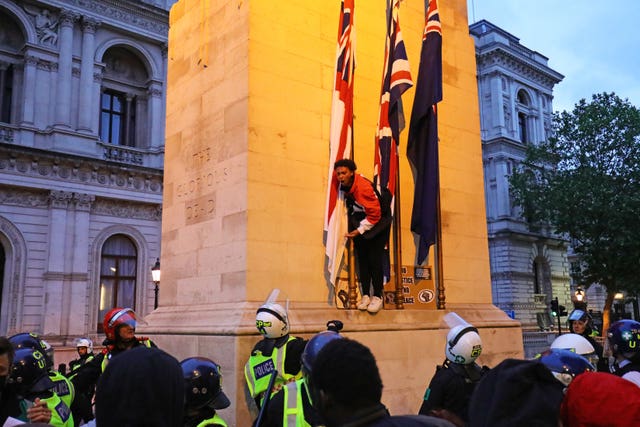 A protester stands on the cenotaph in Whitehall 