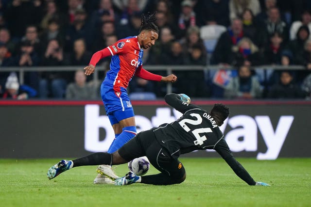 Manchester United goalkeeper Andre Onana, right, saves at the feet of Crystal Palace’s Michael Olise