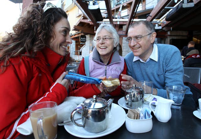 Great Britain’s Amy Williams, left, shows her gold medal to her mum Jan and dad Ian