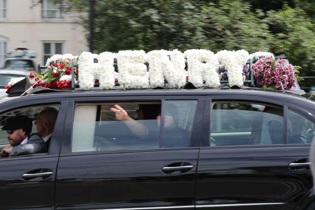 A passenger gestures from a vehicle that forms part of the funeral cortege of burglar Henry Vincent (Gareth Fuller/PA)