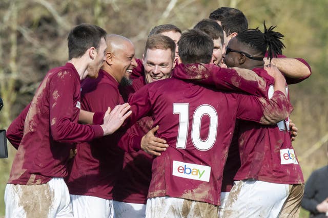 Roberto Carlos is mobbed by his Bull in the Barne United team-mates