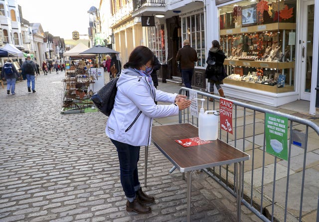 A lady uses hand sanitiser in Guildford, Surrey