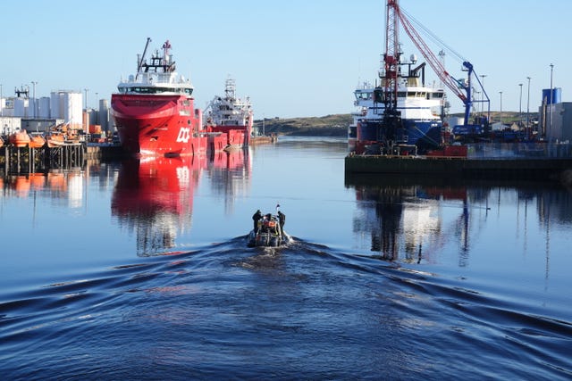 Police boat in harbour, with large ships in the background