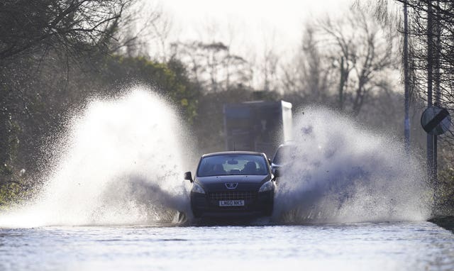 A vehicle drives through flood water in Allerton Bywater near Leeds.