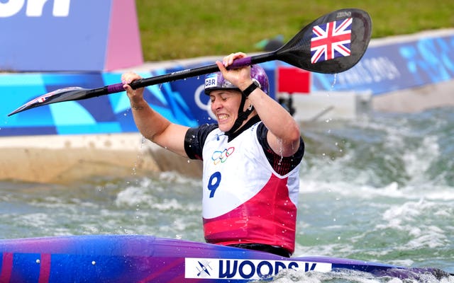 Great Britain’s Kimberley Woods celebrates as she crosses the finish line by raising her oars above her head. 