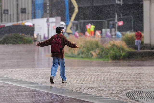 A man embraces a rain shower